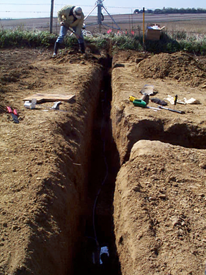 Jason Vogel begins filling in the trench during installation of equipment at the vadose zone monitoring site.