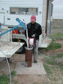Measuring a water-level in a well (Photo by Pete McMahon, USGS).